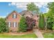 Beautiful brick home with a stone facade, lush landscaping, and a welcoming walkway at 8905 Landsdowne Ave, Harrisburg, NC 28075