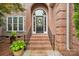 Elegant brick entryway with a welcoming arched doorway and decorative potted plants at 8905 Landsdowne Ave, Harrisburg, NC 28075