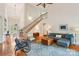 Bright living room features hardwood floors, a staircase, and natural light from the front entryway at 8905 Landsdowne Ave, Harrisburg, NC 28075