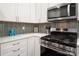 Close up of the modern kitchen with stainless steel oven and microwave and granite backsplash at 901 Southland Rd, Huntersville, NC 28078