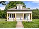 Charming bungalow featuring a covered front porch with wood columns, fresh white paint, and manicured lawn at 906 Church St, Kings Mountain, NC 28086