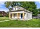Side view of a charming white bungalow with a covered front porch, blue door, and well-kept lawn at 906 Church St, Kings Mountain, NC 28086