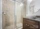 Updated bathroom featuring a glass shower, decorative sink, and tiled walls at 911 Balsam Ter, Charlotte, NC 28214