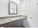 Modern bathroom featuring granite countertop, decorative mirror, and stylish vanity at 911 Balsam Ter, Charlotte, NC 28214