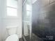 Bathroom showcasing tiled shower with glass door and modern fixtures and toilet at 911 Balsam Ter, Charlotte, NC 28214