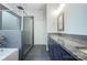 Stylish bathroom features a double vanity, a tiled shower with glass door, and modern fixtures at 911 Balsam Ter, Charlotte, NC 28214