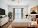 Staged bedroom featuring neutral tones, a large window, and stylish decor at 911 Balsam Ter, Charlotte, NC 28214