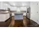 Well-lit kitchen with white cabinetry, stainless steel appliances, granite countertops, and a central island at 911 Balsam Ter, Charlotte, NC 28214