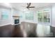 Well-lit living room with hardwood floors, fireplace, large windows, and sliding doors to a deck at 911 Balsam Ter, Charlotte, NC 28214