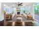 Bright, staged living room with fireplace, ceiling fan, and hardwood floors, complemented by natural light from large windows at 911 Balsam Ter, Charlotte, NC 28214