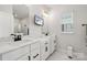 A modern bathroom with double sinks, white cabinets, and black hardware at 9823 Oaklawn Nw Blvd, Huntersville, NC 28078
