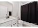 Well-lit bathroom featuring a modern white vanity and a shower with a sleek black curtain at 9823 Oaklawn Nw Blvd, Huntersville, NC 28078