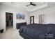 Primary bedroom featuring a TV, walk-in closet, ceiling fan, and modern decor at 9823 Oaklawn Nw Blvd, Huntersville, NC 28078