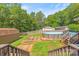Landscaped backyard with above-ground pool, deck, wooden sheds and wood privacy fence at 1005 Caldon Dr, Stanley, NC 28164