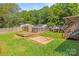 Backyard featuring an above ground pool, fenced yard, a deck, and multiple outbuildings at 1005 Caldon Dr, Stanley, NC 28164