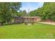 Charming home with a covered porch, green lawn, and mature trees in the background at 1005 Caldon Dr, Stanley, NC 28164