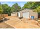 View of two spacious metal garages with concrete driveway and wooded area at 1005 Caldon Dr, Stanley, NC 28164