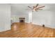 Open living room with fireplace, ceiling fan and hardwood flooring at 1005 Caldon Dr, Stanley, NC 28164
