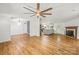 Open-concept living room boasts a ceiling fan, wood floors, a fireplace, and seamless flow to the kitchen at 1005 Caldon Dr, Stanley, NC 28164