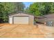 Metal outbuilding with a roll up door and attached carport on a concrete pad at 1005 Caldon Dr, Stanley, NC 28164