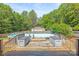 Inviting backyard pool surrounded by lush greenery and a wooden deck, perfect for summer fun at 1005 Caldon Dr, Stanley, NC 28164