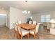 Dining room with a chandelier, wood floors, and seating for six, connected to the living area at 1026 Kirby Dr, Fort Mill, SC 29715