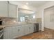 Galley kitchen with stainless steel appliances, gray cabinets, granite countertops, and a view of the living area at 1026 Kirby Dr, Fort Mill, SC 29715