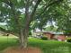 Home situated in shady lot, with mature trees and brick facade visible from afar at 1165 Mt Moriah Church Rd, China Grove, NC 28023