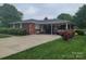 Brick home featuring a covered parking area, tidy hedges, and a well maintained driveway at 1165 Mt Moriah Church Rd, China Grove, NC 28023