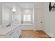 Bright bathroom featuring a soaking tub, herringbone floors, and a marble countertop vanity at 1304 Lookout Cir, Waxhaw, NC 28173