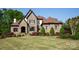 Beautiful stone and brick home with manicured lawn, lush landscaping, and a classic, timeless design at 1304 Lookout Cir, Waxhaw, NC 28173