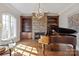 Elegant living room with a grand piano, fireplace, and built-in bookshelves for a refined ambiance at 1304 Lookout Cir, Waxhaw, NC 28173