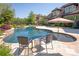 Outdoor in-ground pool and spa surrounded by travertine tile and lounge seating at 1304 Lookout Cir, Waxhaw, NC 28173