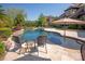 Backyard pool with lounge chairs and outdoor seating with a beautiful waterfall feature at 1304 Lookout Cir, Waxhaw, NC 28173