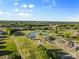 Expansive aerial view showcasing a beautiful golf course community with a pond and clubhouse at 1308 Stone Marker Dr, Monroe, NC 28112
