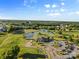 Beautiful aerial view of a golf course community, showing a scenic pond, clubhouse, and ample parking at 1308 Stone Marker Dr, Monroe, NC 28112