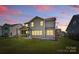 Backyard with fire pit, concrete patio and screened in porch on the house at sunset at 1308 Stone Marker Dr, Monroe, NC 28112