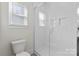 Clean bathroom featuring glass shower with tiled walls, a toilet, and a window at 1308 Stone Marker Dr, Monroe, NC 28112