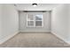 Cozy bedroom featuring neutral carpet, trim, and fresh paint, with a large window that lets in natural light at 1308 Stone Marker Dr, Monroe, NC 28112