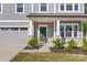 Inviting front porch with stone accents, a dark front door, and manicured landscaping at 1308 Stone Marker Dr, Monroe, NC 28112