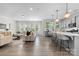 Open-concept living area with modern furnishings, flowing into a bright kitchen with a breakfast bar at 1308 Stone Marker Dr, Monroe, NC 28112