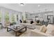 Bright, open living space with modern furnishings, large windows, and a view into the kitchen at 1308 Stone Marker Dr, Monroe, NC 28112