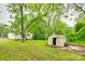 A serene backyard with a storage shed, lush trees, and the home's exterior at 146 Walnut St, Chester, SC 29706