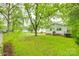 A spacious backyard with green grass, lush trees, and the home's exterior in view at 146 Walnut St, Chester, SC 29706