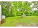 A spacious backyard with green grass, mature trees, and a storage shed at 146 Walnut St, Chester, SC 29706