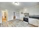 Cozy kitchen featuring white cabinets and stove, light grey floors, and wall shelving at 146 Walnut St, Chester, SC 29706