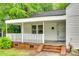 Inviting covered porch with brick steps and white railing, perfect for relaxing at 146 Walnut St, Chester, SC 29706