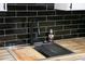 Kitchen featuring a stainless steel sink, black faucet, black tiled backsplash and butcher block counters at 149 Glenwood Dr, Rock Hill, SC 29732