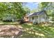 The home's backyard with a deck and storage shed offers a tranquil retreat surrounded by lush greenery at 16320 Peach Grove Ln, Charlotte, NC 28277