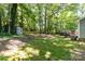 Expansive backyard view with mature trees, a storage shed, and lush landscaping, offering a peaceful setting at 16320 Peach Grove Ln, Charlotte, NC 28277